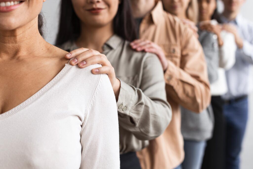 Un fila de profesionales apoyando sus manos en el hombre del profesional delante de cada uno