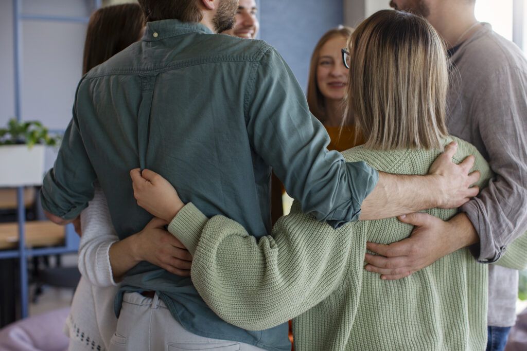 Un conjunto de profesionales en circulo, apoyándose mutuamente