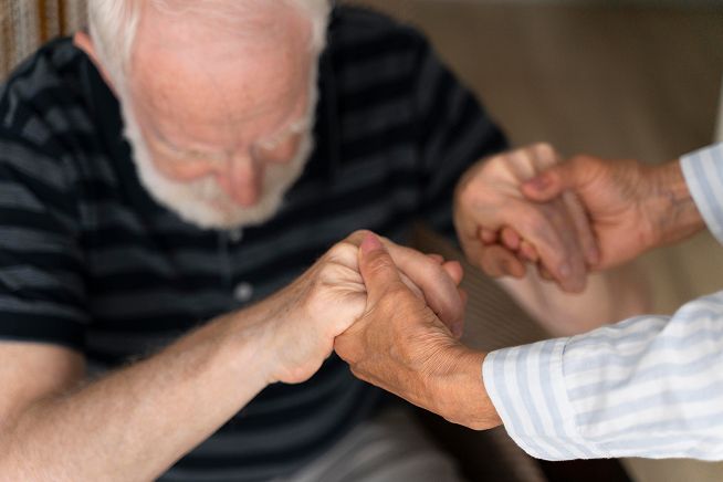 Una persona de la tercera edad siendo asistido para que se reincorpore
